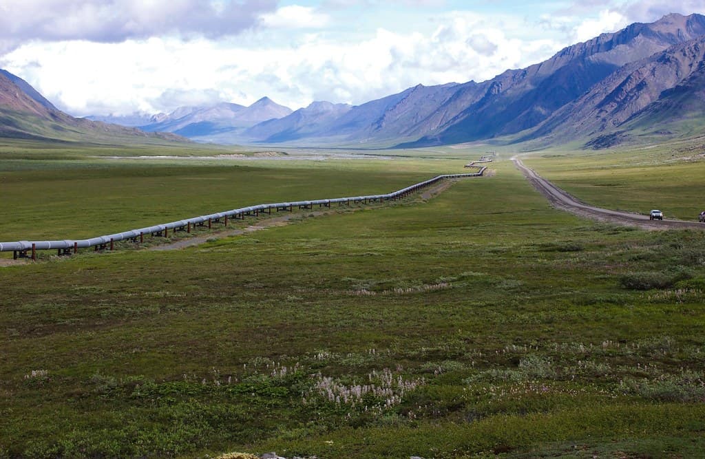 Pipeline corridor running alongside a road through open terrain